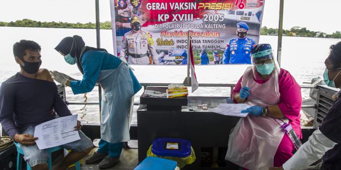 MENYASAR WARGA PINGGIRAN: Tim vaksinator sedang menjalankan tugas di atas kapal milik Ditpolairud. (FOTO: AGUS PRAMONO/KALTENG POS)