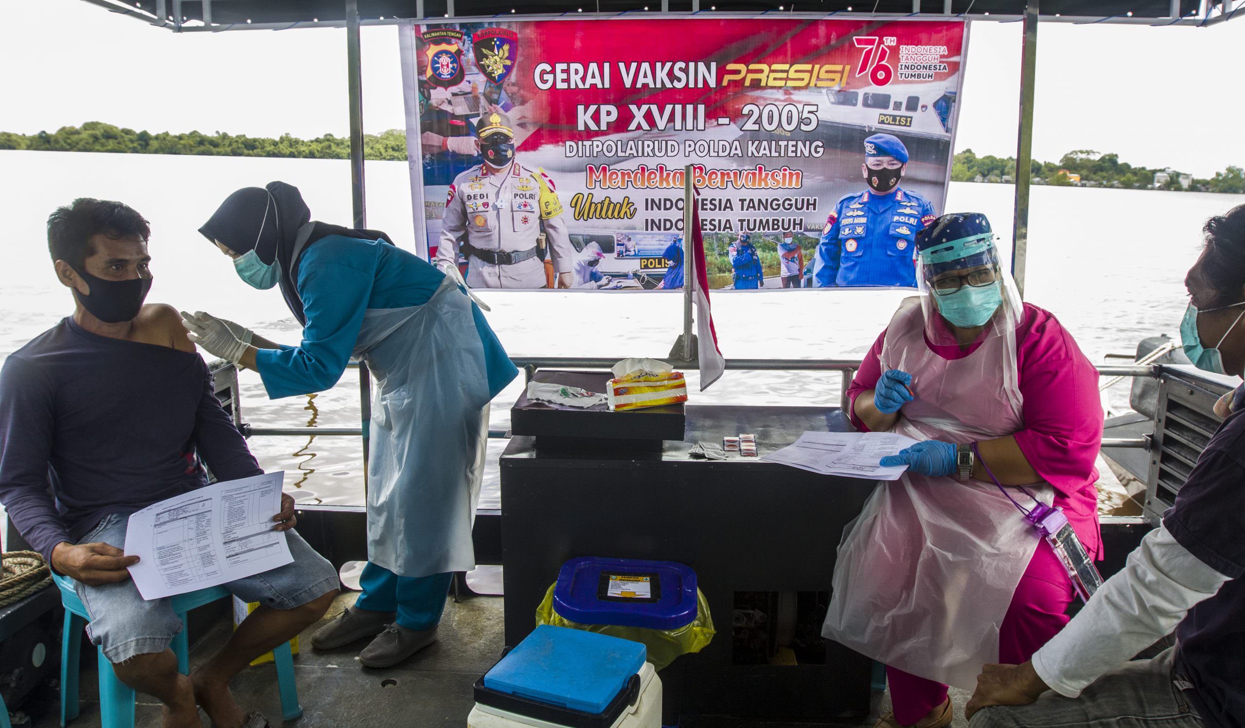 MENYASAR WARGA PINGGIRAN: Tim vaksinator sedang menjalankan tugas di atas kapal milik Ditpolairud. (FOTO: AGUS PRAMONO/KALTENG POS)