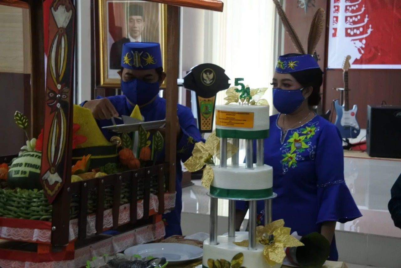 SEMANGAT:  Bupati Barito Timur Ampera AY Mebas didampingi istri, Munita Mustika Dewi memotong tumpeng hari jadi ke-19 Kabupaten Bartim, Selasa (3/8). (FOTO: LOGMAN/KALTENG POS )