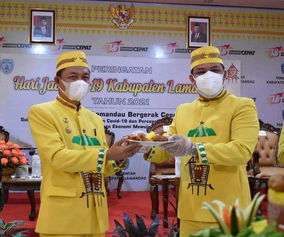 SINERGITAS : Bupati Lamandau H Hendra Lesmana (kanan) menyerahkan nasi tumpeng kepada Wakil Bupati Lamandau Riko Porwanto pada peringatan HUT ke-19 Kabupaten Lamandau, beberapa waktu lalu. (FOTO: HUMAS UNTUK KALTENG POS)