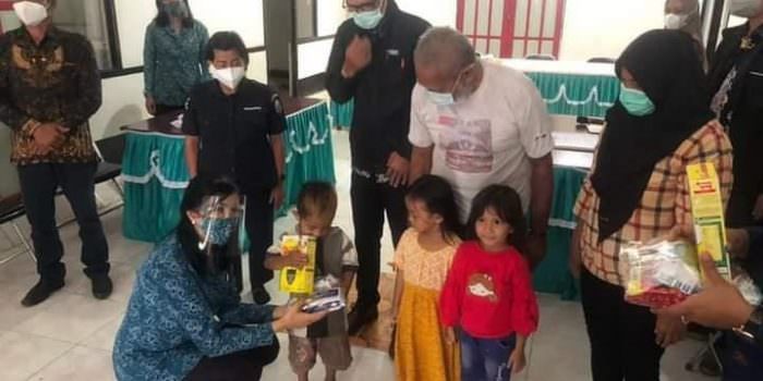 PEDULI ANAK: Ketua TP PKK Mura, Lynda Kristiane Perdie menyerahkan susu formula kepada balita di Desa Muara Jaan, disaksikan Camat Murung, Fitrianul Fahriman, baru-baru ini. (FOTO:HUMAS UNTUK KALTENG POS)