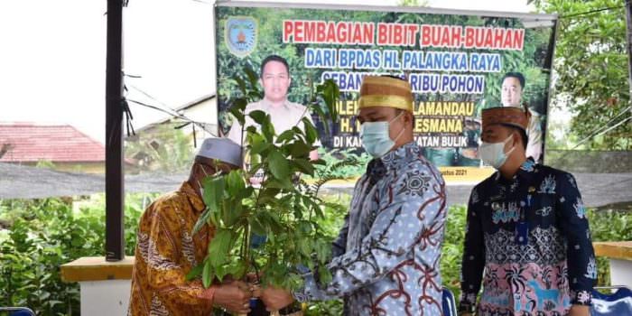 SALURKAN BANTUAN : Bupati Lamandau H Hendra Lesmana (kanan) menyalurkan bantuan bibit buah-buahan kepada perwakilan warga di kawasan Kantor Kecamatan Bulik, Kabupaten Lamandau, belum lama ini. (FOTO: HUMAS UNTUK KALTENG POS)