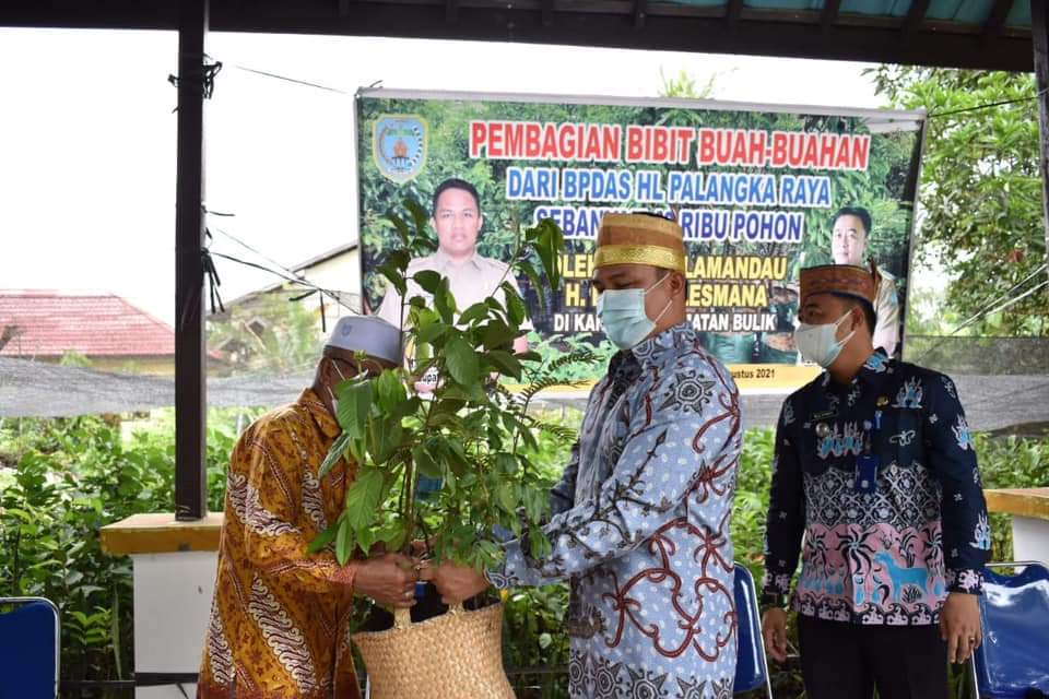 SALURKAN BANTUAN : Bupati Lamandau H Hendra Lesmana (kanan) menyalurkan bantuan bibit buah-buahan kepada perwakilan warga di kawasan Kantor Kecamatan Bulik, Kabupaten Lamandau, belum lama ini. (FOTO: HUMAS UNTUK KALTENG POS)