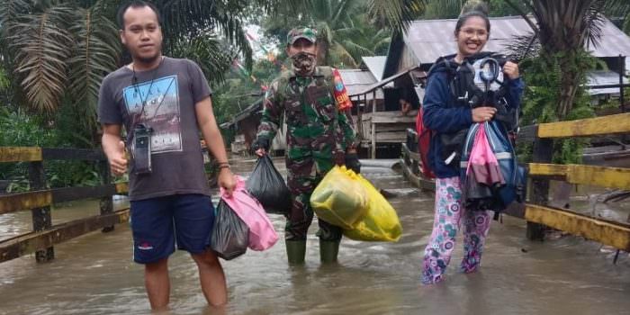 PEDULI: Babinsa Sambi Kopda M Erfan Taufik, Koramil 1014 - 04/Aruta membantu warga yang terdampak banjir di wilayah binaannya, di Desa Sambi, Kecamatan Arut Utara, Kabupaten Kobar, Minggu (22/8). (FOTO: PENREM 102/Pjg)