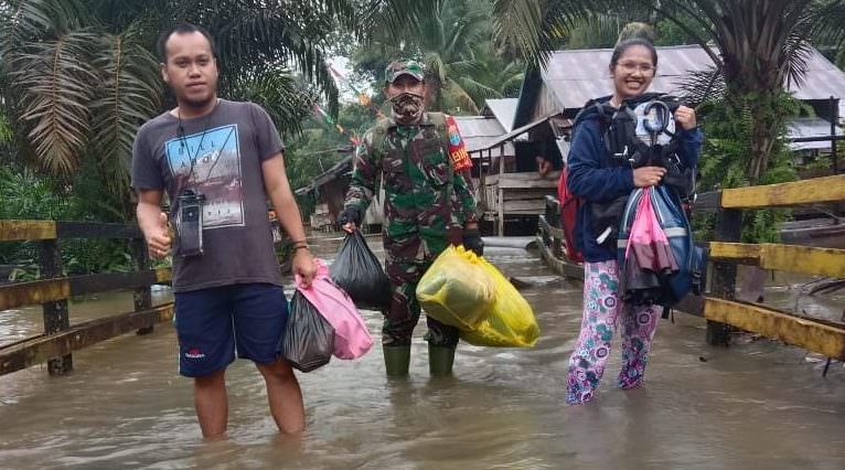 PEDULI: Babinsa Sambi Kopda M Erfan Taufik, Koramil 1014 - 04/Aruta membantu warga yang terdampak banjir di wilayah binaannya, di Desa Sambi, Kecamatan Arut Utara, Kabupaten Kobar, Minggu (22/8). (FOTO: PENREM 102/Pjg)