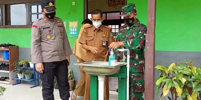 PENGECEKAN: Danramil 1015-09/Baamang Kapten Inf Wiranto ikut memantau pelaksanaan pendaftaran PPDB 2021 dan mengecek penerapan protokol kesehatan di SMPN-3 Sampit, Senin (30/8). (FOTO: PENREM 102/Pjg)