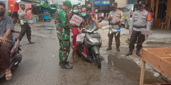 EDUKASI: Babinsa Kelurahan Kumai Hulu Kopda Agus Tarmudi, Koramil 1014 - 02/Kumai bersama tim gabungan memberikan edukasi protokol kesehatan Covid-19 kepada masyarakat yang sedang melintas di jalan Bendahara dan Pasar Cempaka, Kecamatan Kumai, Kabupaten Kobar, (20/8). (FOTO: PENREM 102/Pjg)