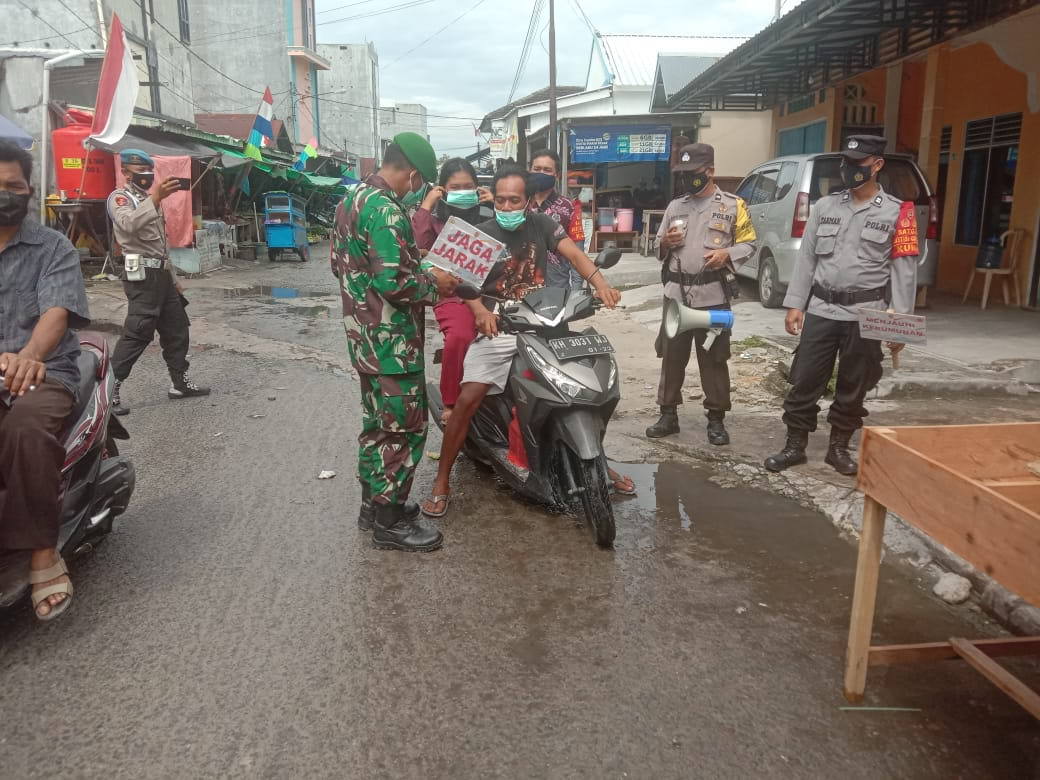 EDUKASI: Babinsa Kelurahan Kumai Hulu Kopda Agus Tarmudi, Koramil 1014 - 02/Kumai bersama tim gabungan memberikan edukasi protokol kesehatan Covid-19 kepada masyarakat yang sedang melintas di jalan Bendahara dan Pasar Cempaka, Kecamatan Kumai, Kabupaten Kobar, (20/8). (FOTO: PENREM 102/Pjg)