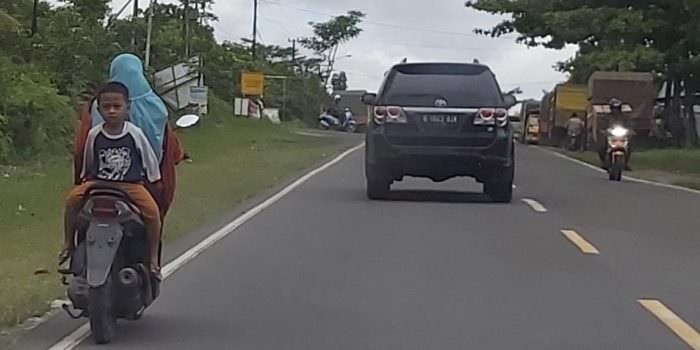 BERBAHAYA : Pengendara motor ini terbilang nekat membonceng anaknya dengan posisi sangat berbahaya di jalan menuju Kumai, Minggu (5/9). (FOTO: SONY/KALTENG POS )