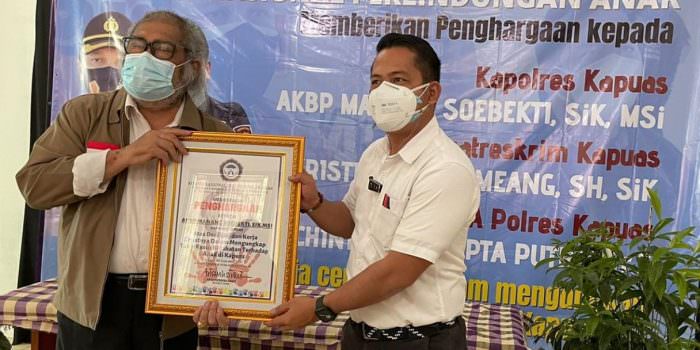 BERPRESTASI: Kasatereskrim Polres Kapuas AKP Kristanto Situmeang saat menerima penghargaan dari Ketua Komisi Nasional Perlindungan Anak, Arist Merdeka Sirait di Jakarta, Jumat (3/9). (DOK. PRIBADI)