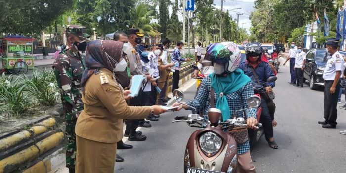 BAGI MASKER: Bupati Kotawaringin Barat Hj Nurhidayah bersama forkopimda membagikan masker kepada para pengendara yang melintas di jalan raya, Senin (20/9). (FOTO:SONY/KALTENG POS )