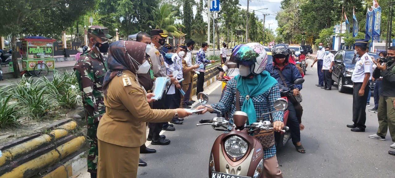 BAGI MASKER: Bupati Kotawaringin Barat Hj Nurhidayah bersama forkopimda membagikan masker kepada para pengendara yang melintas di jalan raya, Senin (20/9). (FOTO:SONY/KALTENG POS )