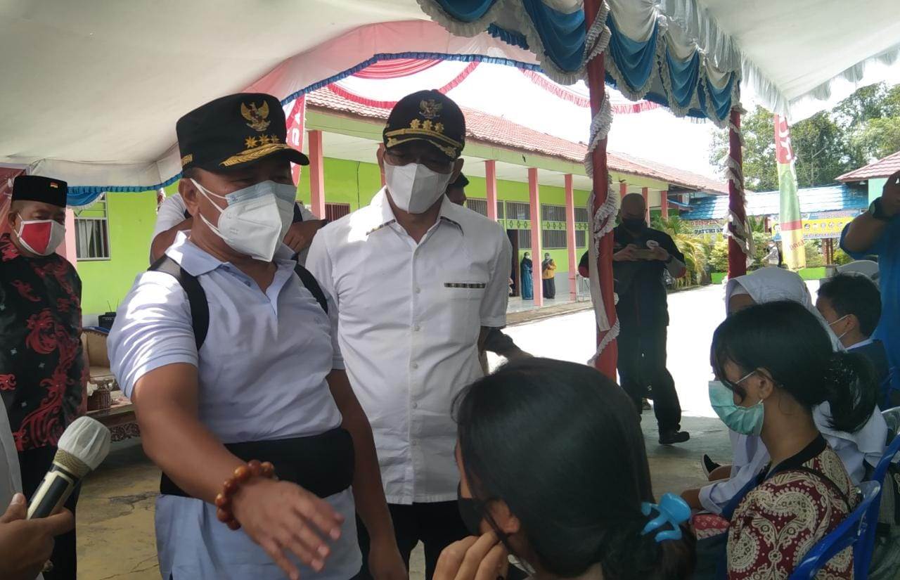 BERI DUKUNGAN: Bupati Mura Perdie M Yoseph mendampingi Gubernur Kalteng Sugianto Sabran memantau jalannya vaksinasi massal bagi pelajar di SMAN 1 Murung, Sabtu (18/9). (FOTO: DADANG/KALTENG POS)