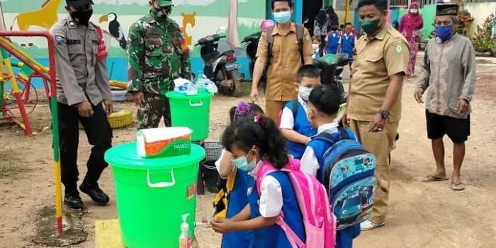 PANTAU: Babinsa Koramil 1015-12/Parenggean Sertu Sarmidi bersama tim gabungan meninjau kesiapan PTM di beberapa sekolah di wilayah Desa Mekar Jaya, Selasa (31/8). (FOTO: PENREM 102/Pjg)