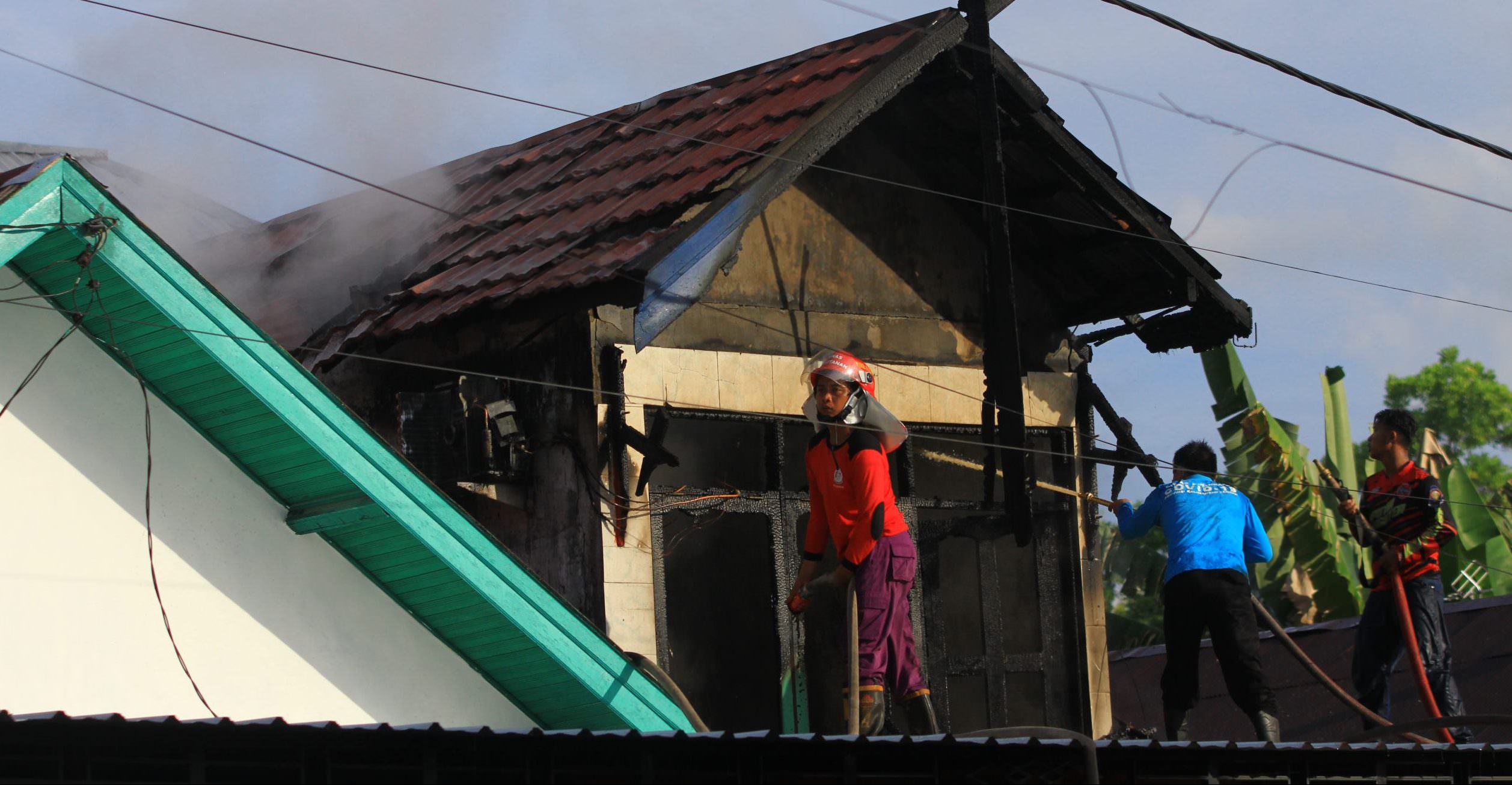 TERBAKAR: Petugas berusaha memadamkan api yang membakar salah satu rumah di Jalan Lais I, Senin (4/10). (FOTO: DENAR/KALTENG POS)