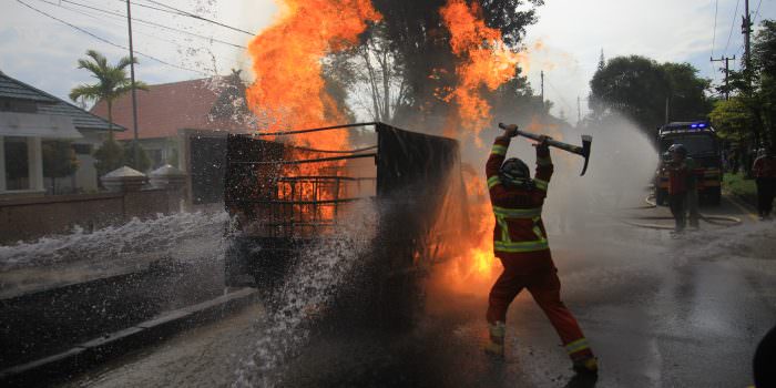 TERBAKAR: Petugas pemadam berupaya memadamkan api di pikap yang diduga mengangkut BBM di Jalan Willem AS, Kota Palangka Raya, Rabu (13/10). (FOTO: DENAR/KALTENG POS)