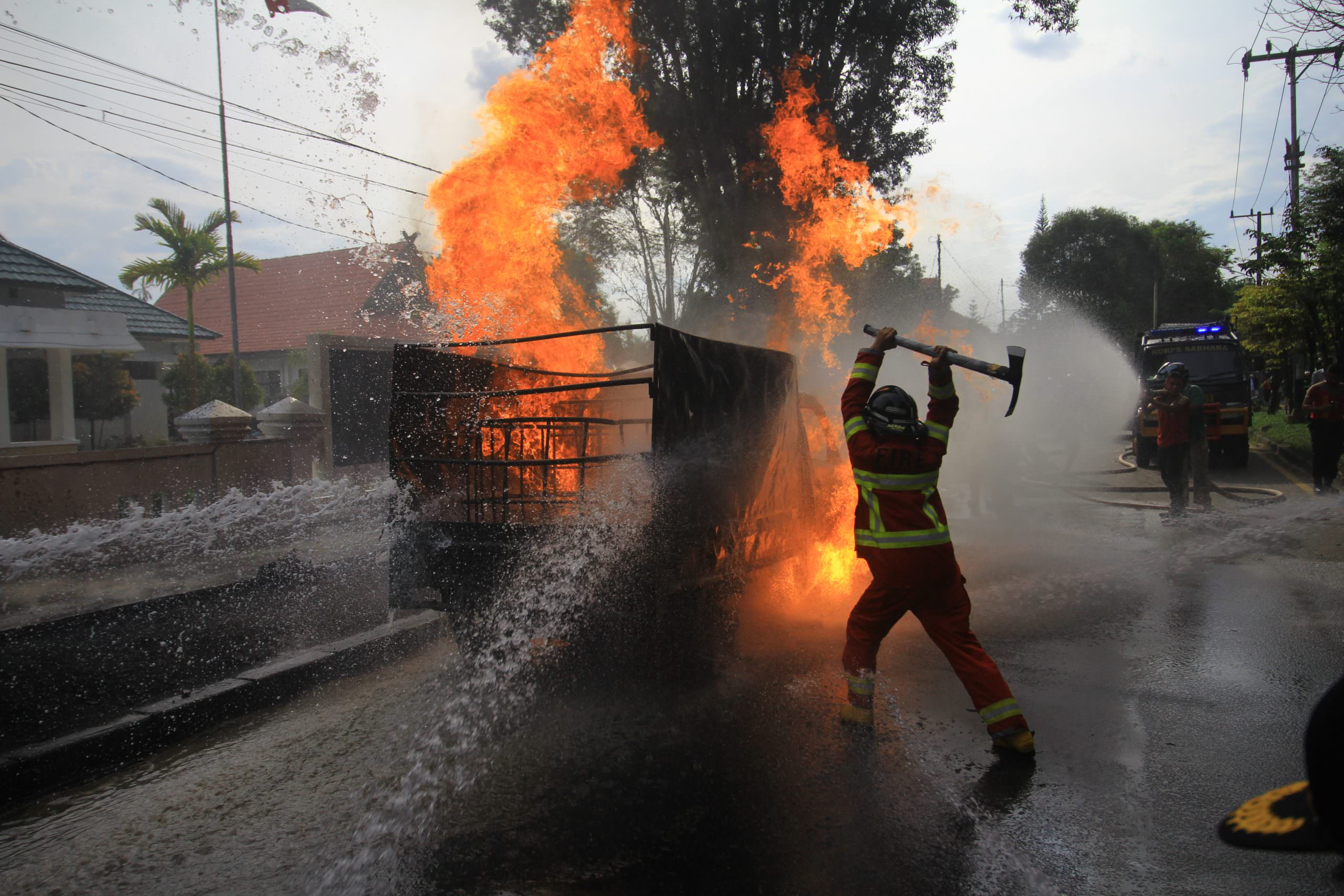 TERBAKAR: Petugas pemadam berupaya memadamkan api di pikap yang diduga mengangkut BBM di Jalan Willem AS, Kota Palangka Raya, Rabu (13/10). (FOTO: DENAR/KALTENG POS)