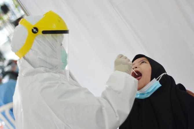 TES PCR: Petugas Kesehatan mengambil sampel usap warga saat mengikuti tes swab PCR di kantor Kecamatan Pancoran Mas, Depok, Jawa Barat, Selasa (5/1/2020). (Dery Ridwansah/ JawaPos.com)