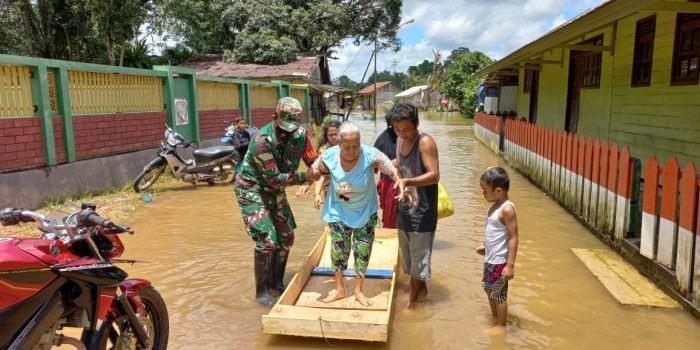 PEDULI: Babinsa Kelurahan Pangkut Praka Eko Yuli membantu mengevakuasi lansia yang rumahnya ikut terendam banjir, Selasa (5/10). (FOTO: PENREM 102/Pjg)