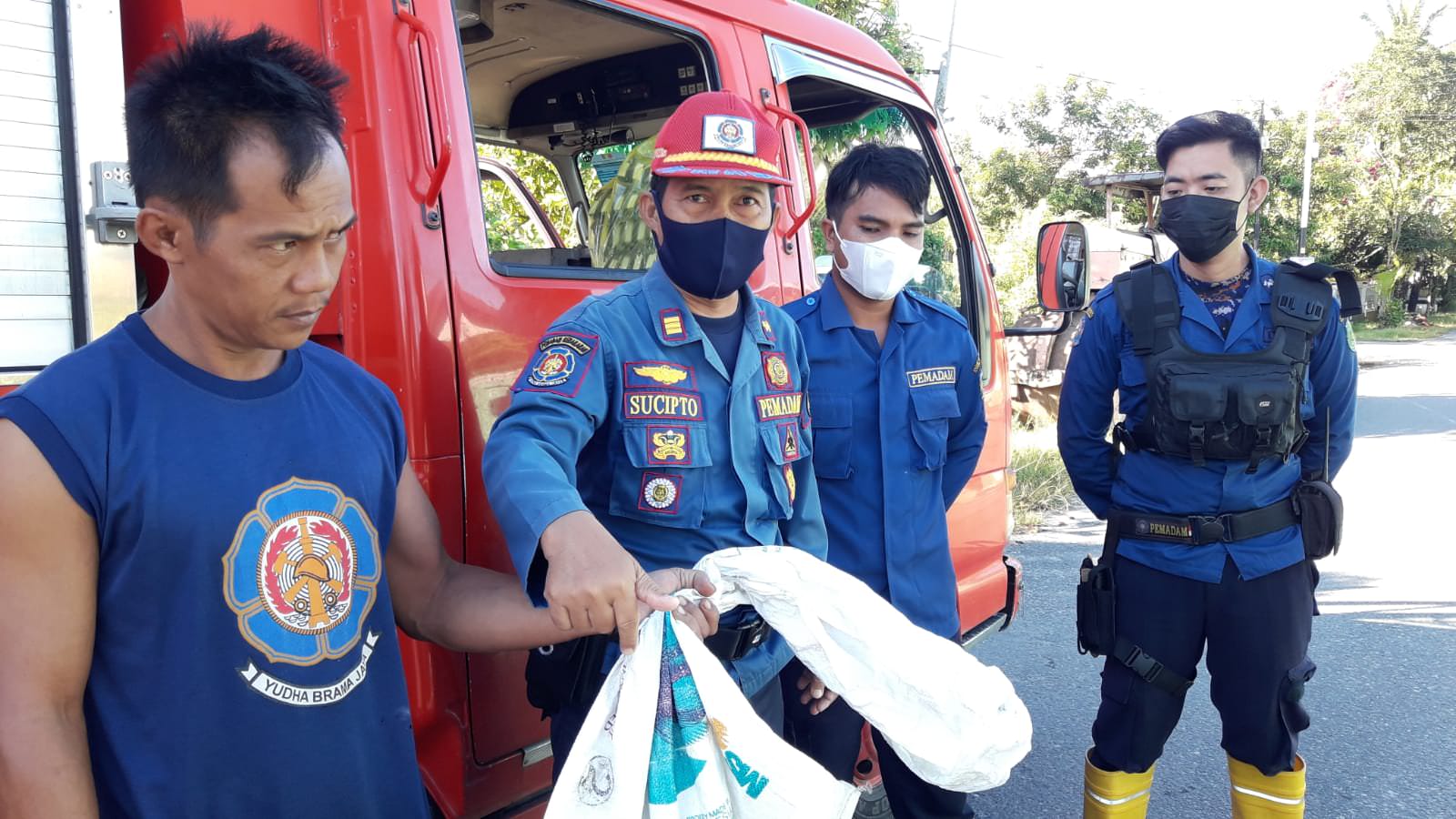 SIGAP: Tim Resque 112 Damkar Kota Palangka Raya mengevakuasi ular jenis piton dengan panjang kurang lebih 1 meter di depan rumah warga Jalan Rajawali III. (FOTO: DAMKAR KOTA UNTUK KALTENG POS)