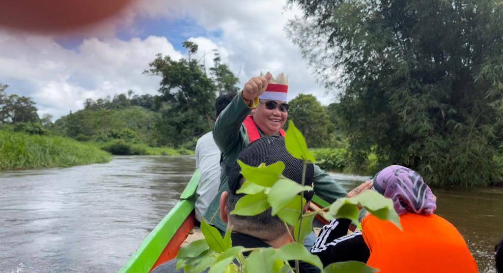 TRANSPORTASI: Bupati Kotawaringin Timur, H Halikinnor menaiki perahu kecil menyusuri sungai menuju ke Desa Tumbang Gagu, Kecamatan Antang Kalang, Rabu (10/11). (FOTO: IST UNTUK KALTENG POS)