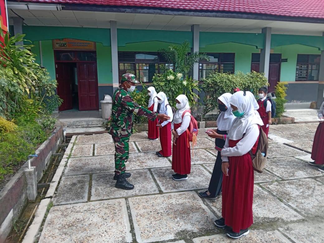 MEMANTAU: Babinsa Koramil 1016-01 Pahandut bersama bhabinkamtibmas dan pihak kelurahan memantau pembelajaran tatap muka di sekolah, Senin (1/11). (foto: PENDIM 1016/PLK)