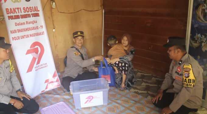Petugas Polsek Dusun Timur menyerahkan sembako kepada anak berkebutuhan khusus di Desa Matabu, serta kerja bakti di masjid dan gereja setempat dalam rangka HUT ke-79 Bhayangkara.